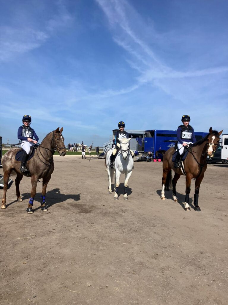Three girls riding horses facing the camera
